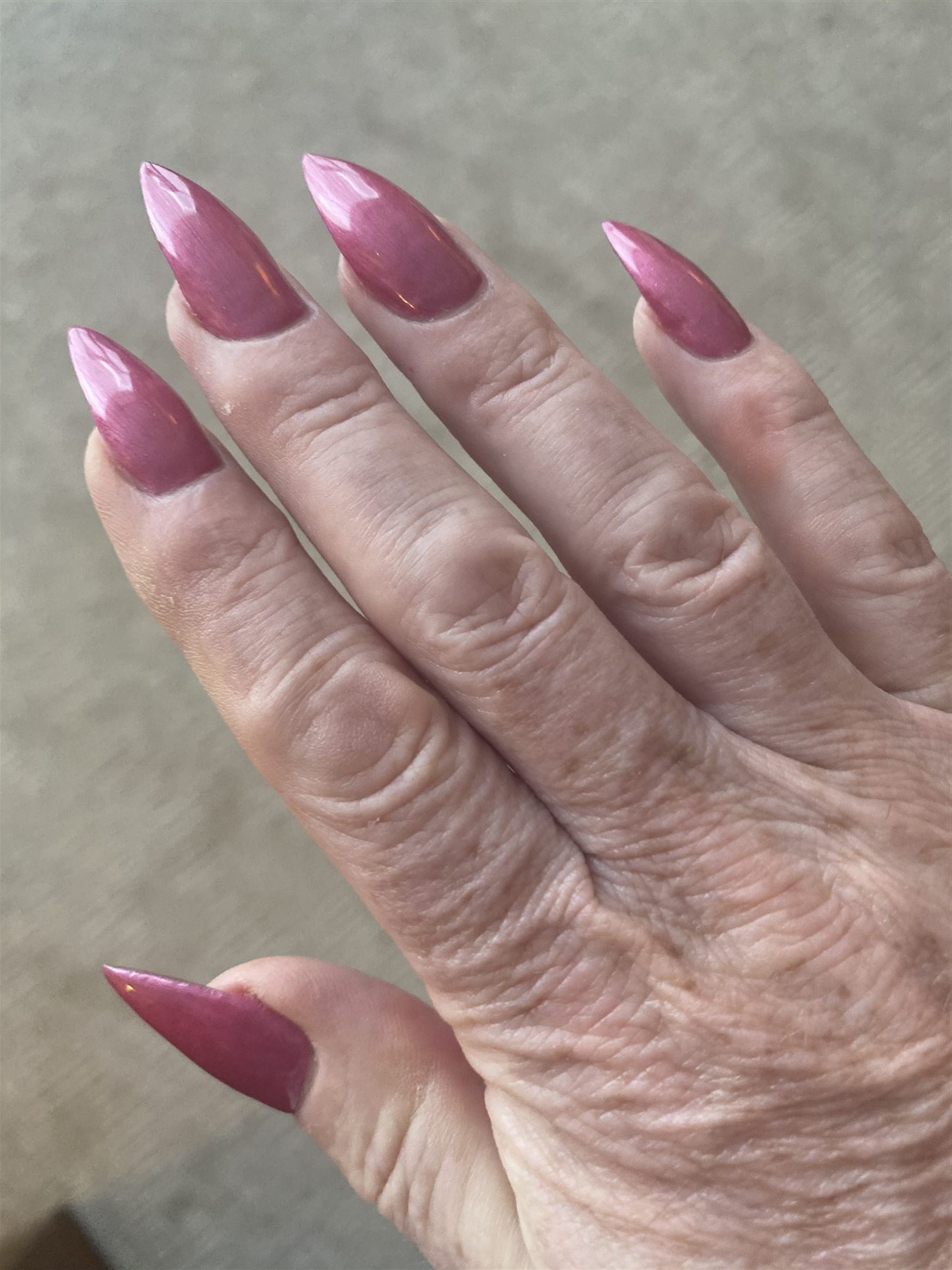 Rose chrome stiletto nails created for a male actor portraying a woman in a film production