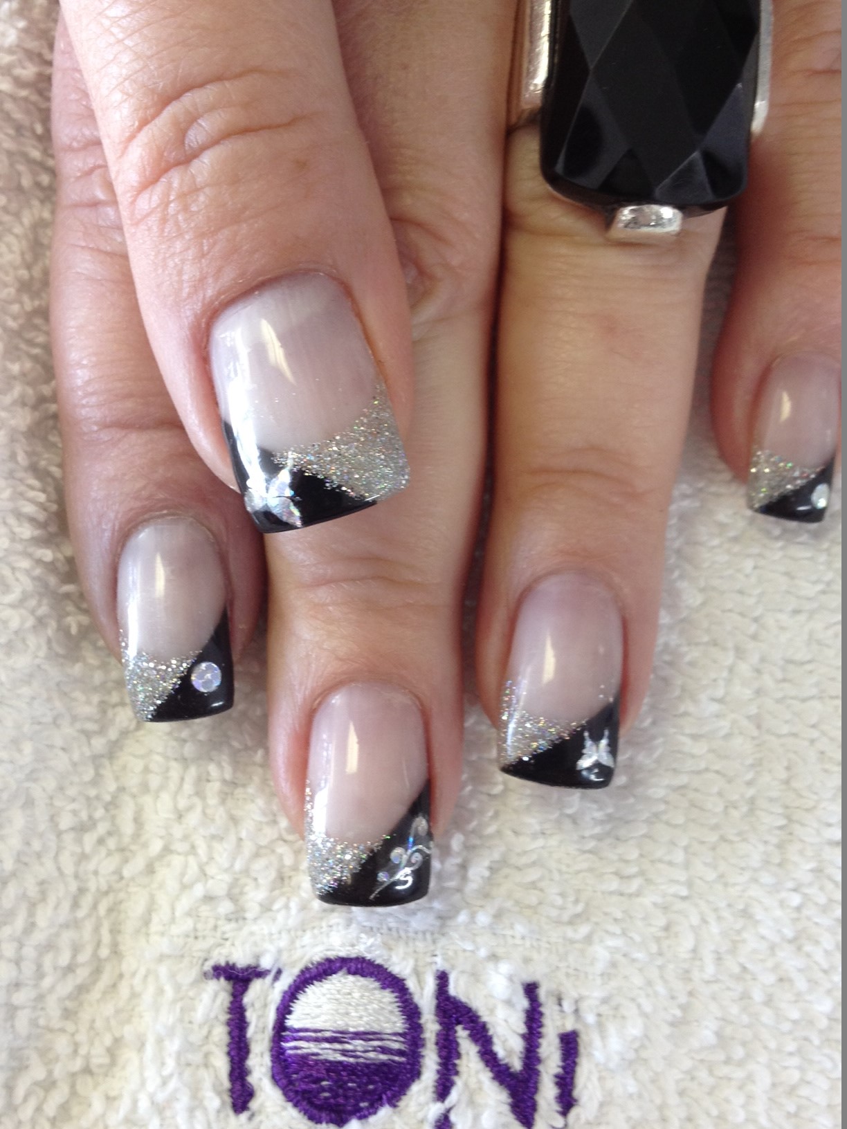 Black and silver glitter French nails with crystal and butterfly accents