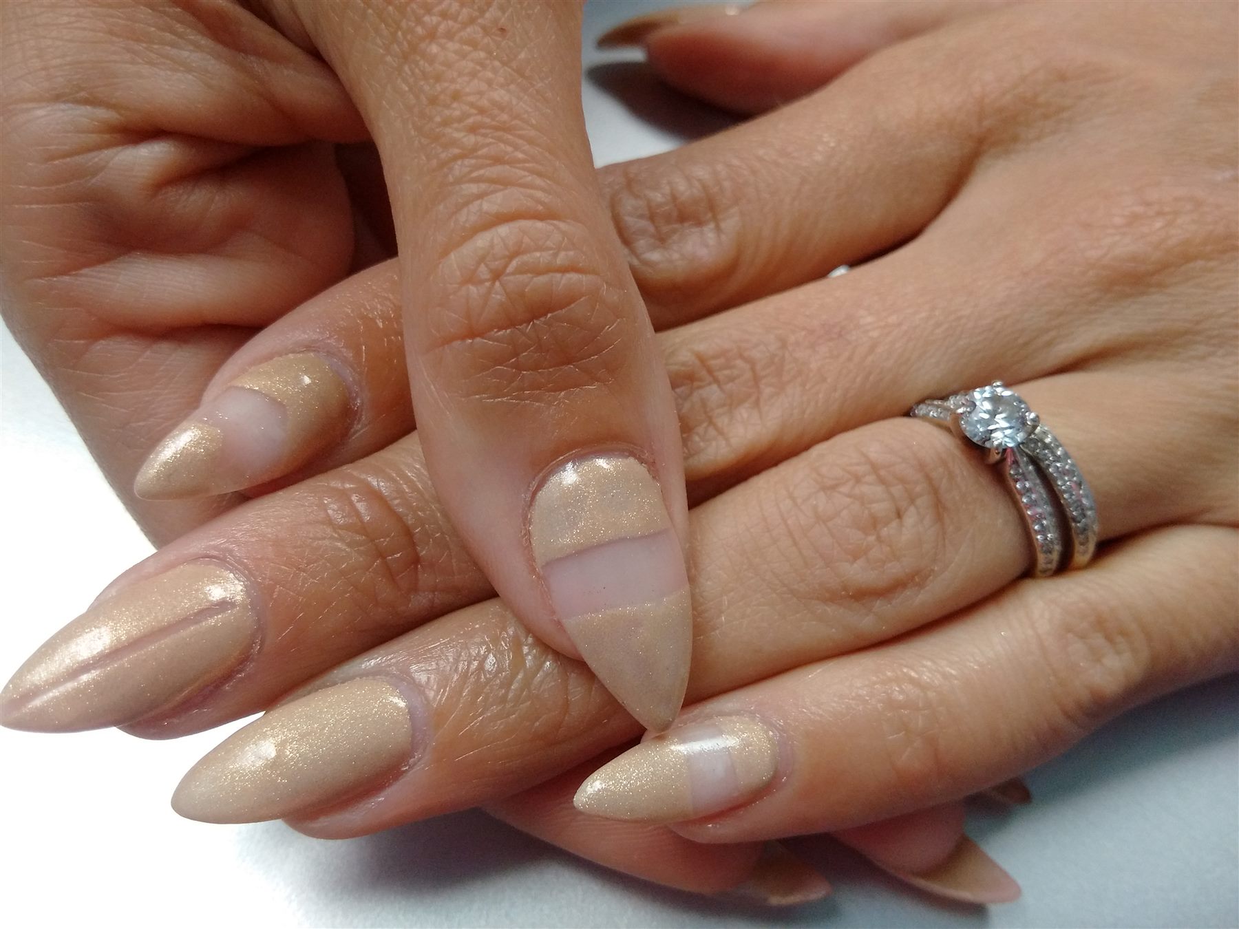 Champagne shimmer nails with horizontal negative-space bands