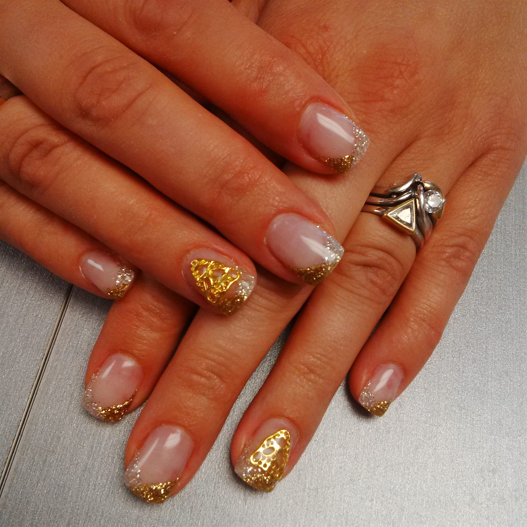 French manicure with gold glitter tips and lace embellishments