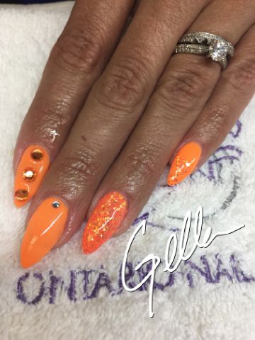 Bright orange nail design with gems and glitter
