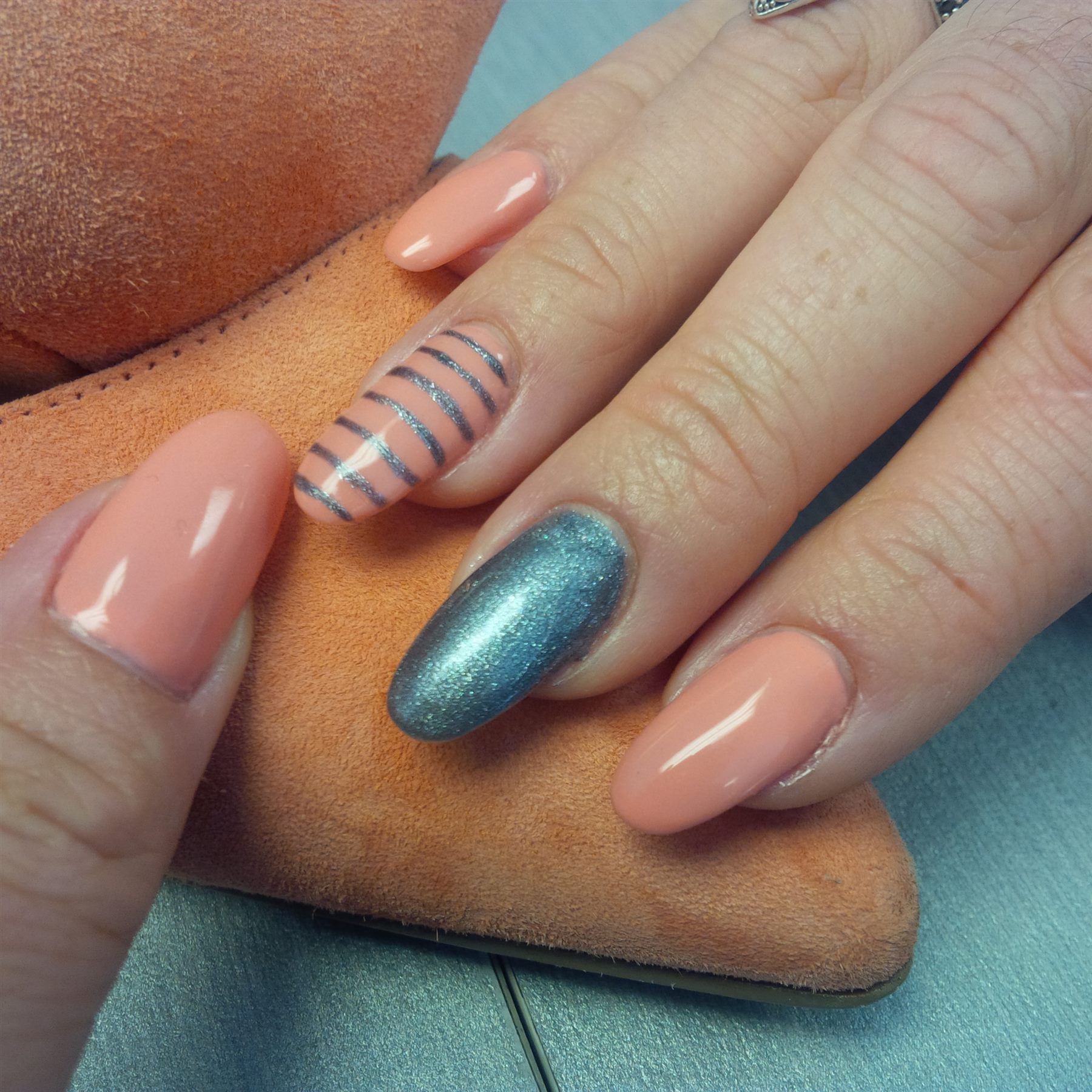 Peach nails with graphite shimmer and striped accent art