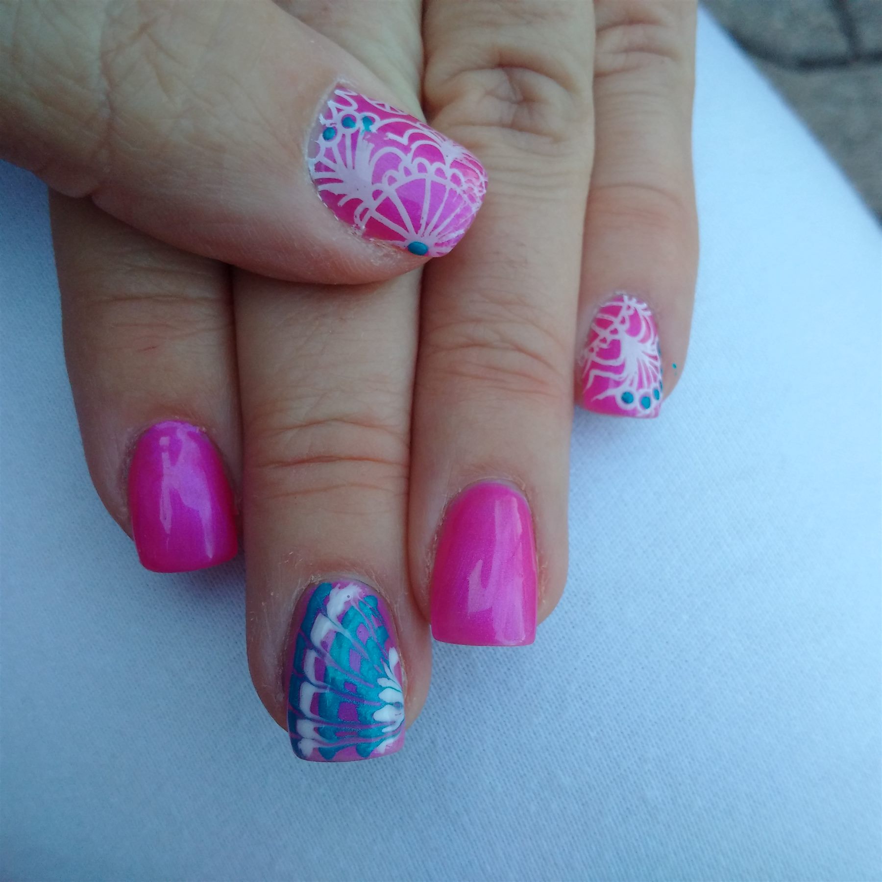 Bright pink nails with white lace and turquoise accent art