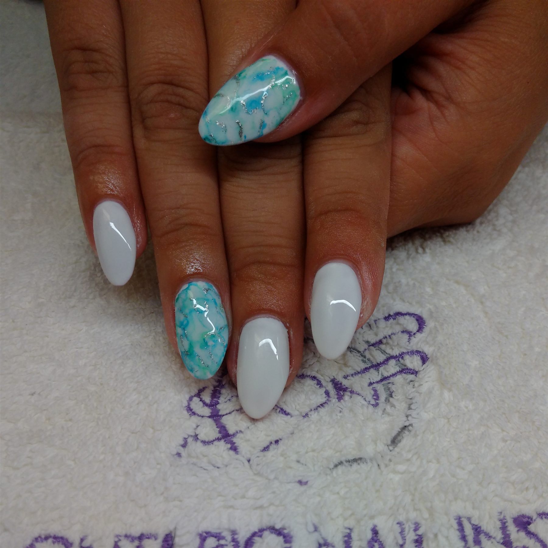 White almond nails with turquoise marble accent art