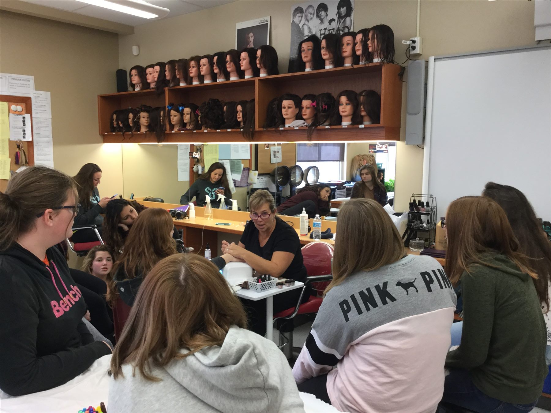 High school students watching a nail educator demonstrate professional techniques