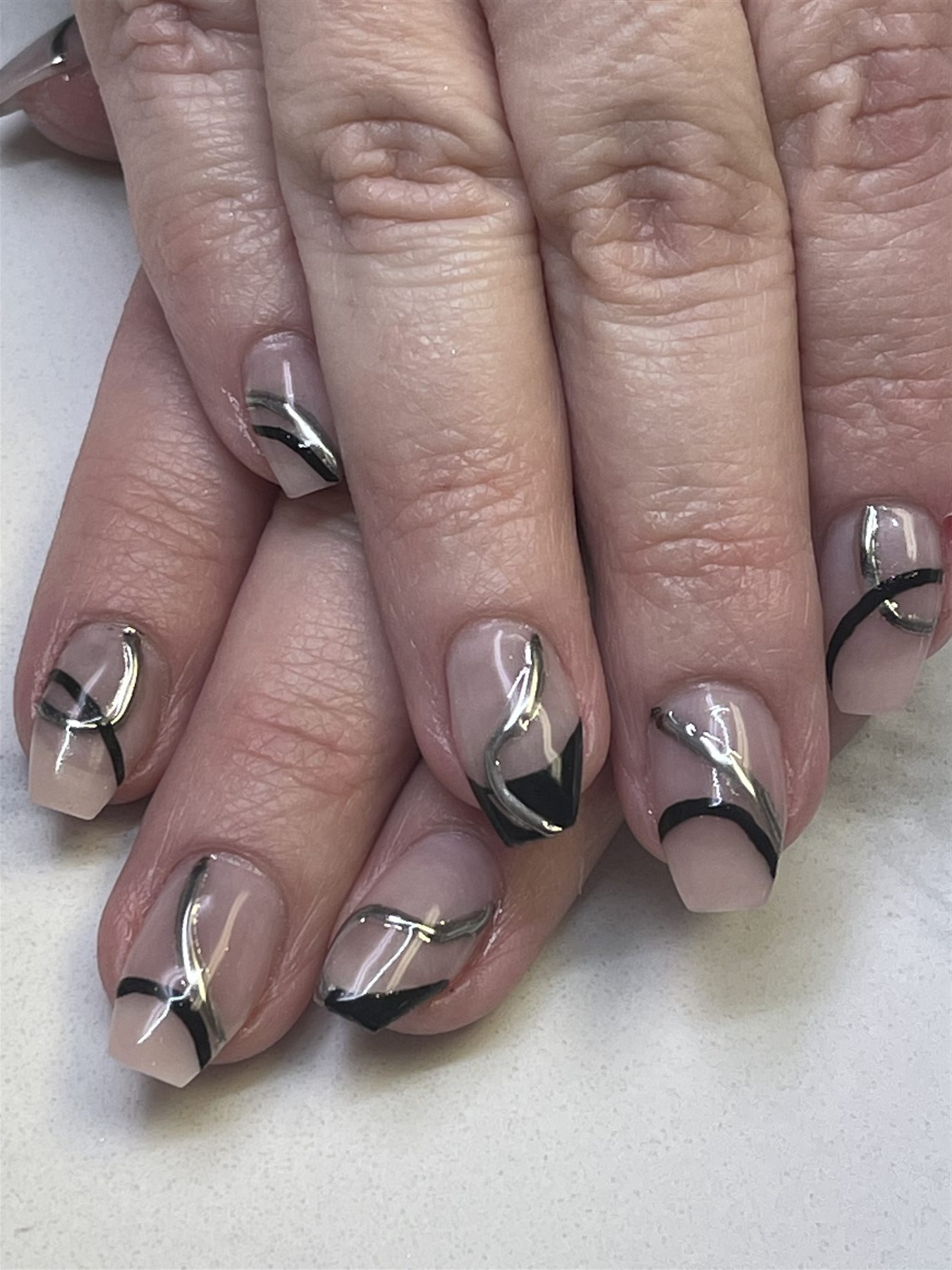 Nude nails with abstract black and silver line art