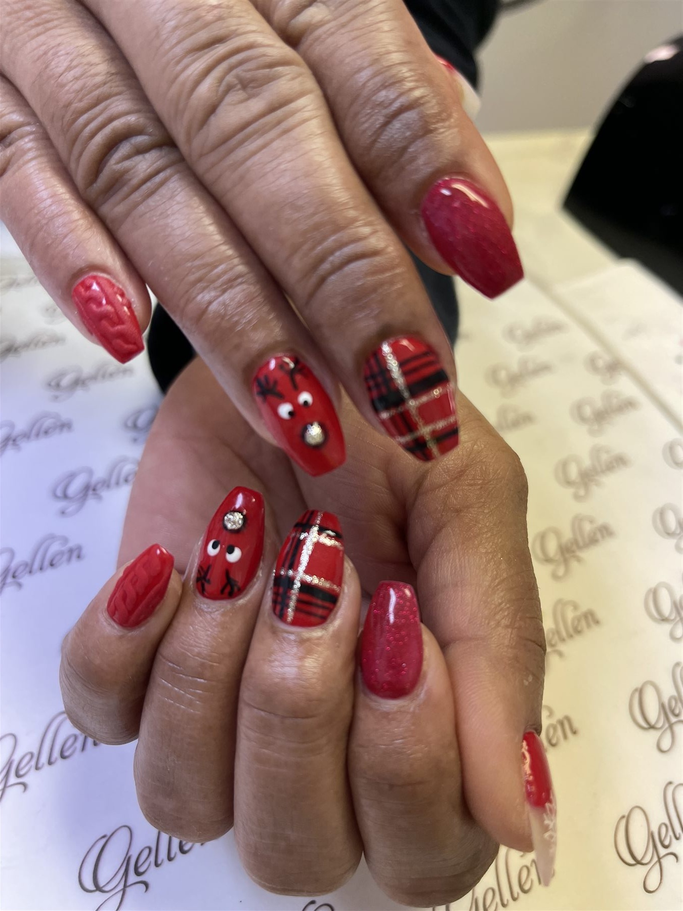 Red Christmas nails with tartan reindeer and sweater accents