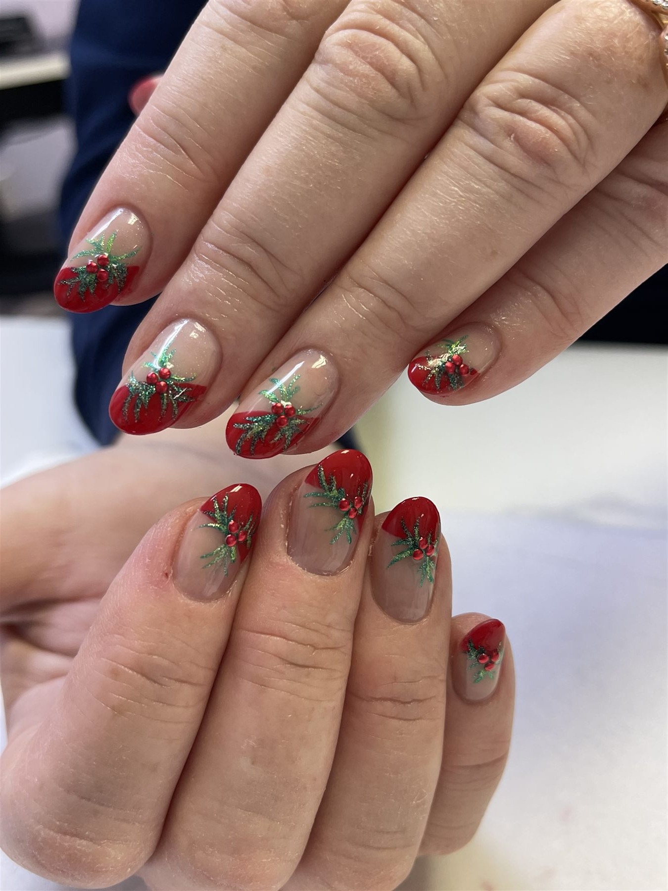 Red French nails with green holly leaves and berry crystals
