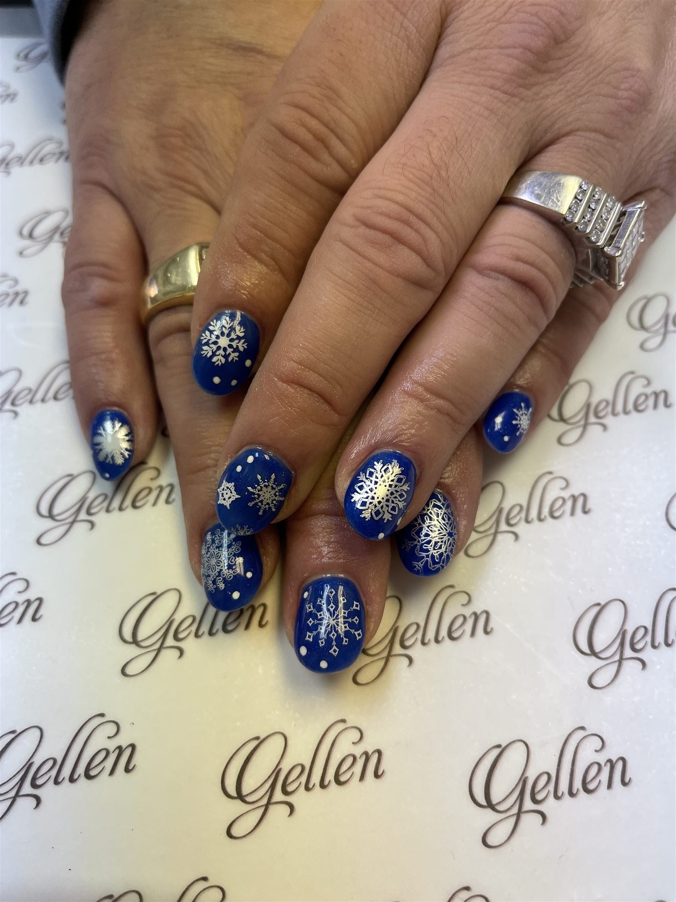 Royal blue nails decorated with white and silver snowflakes