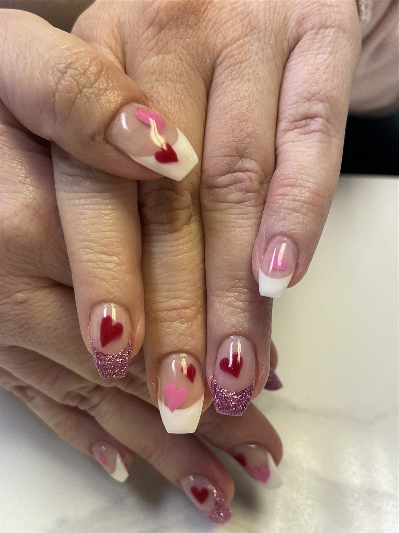 White and pink glitter French nails with red and pink hearts