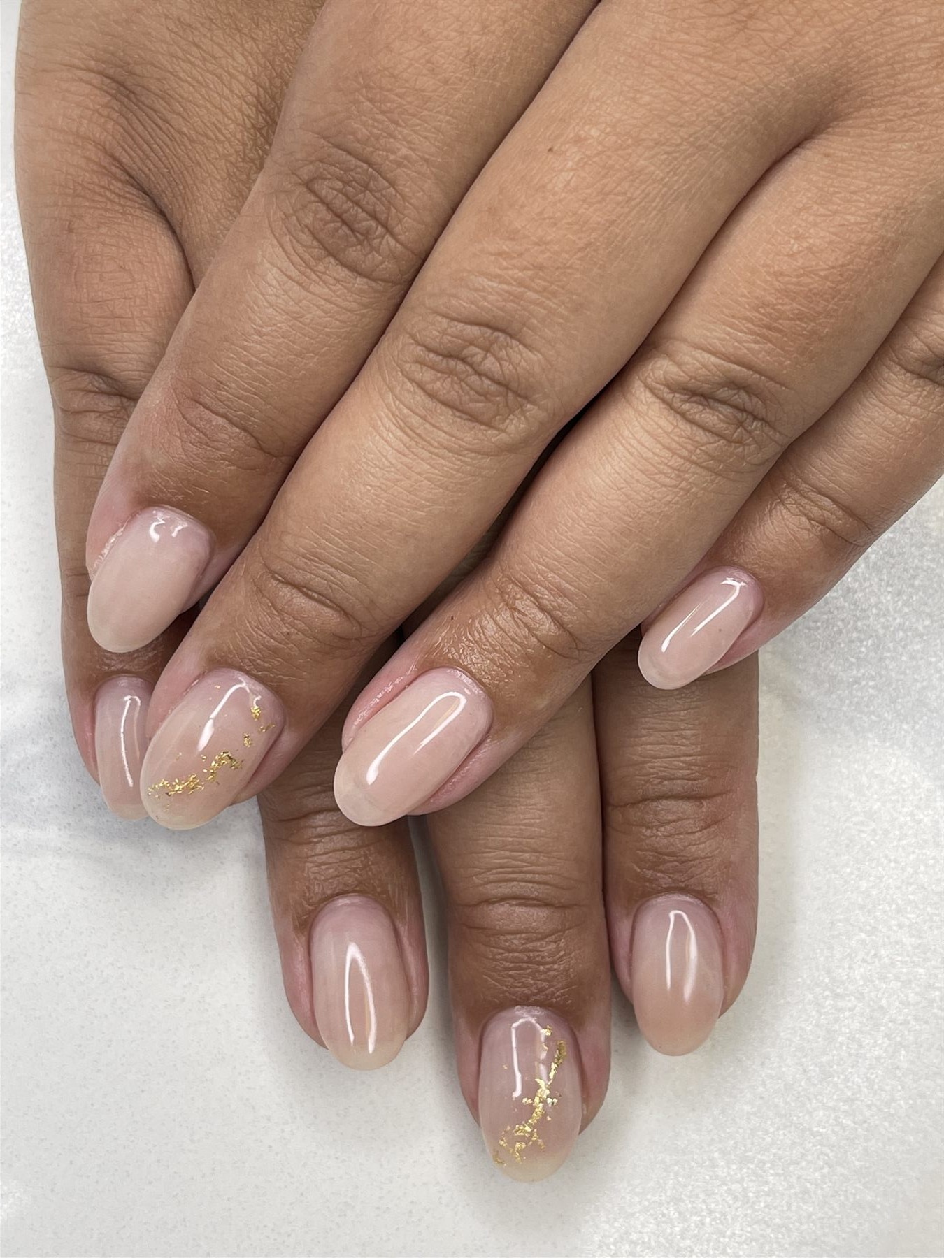 Sheer blush nude nails with delicate gold foil accents