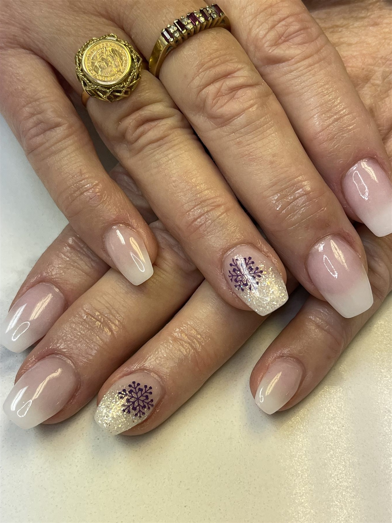 Blush ombre nails with purple snowflakes and iridescent glitter
