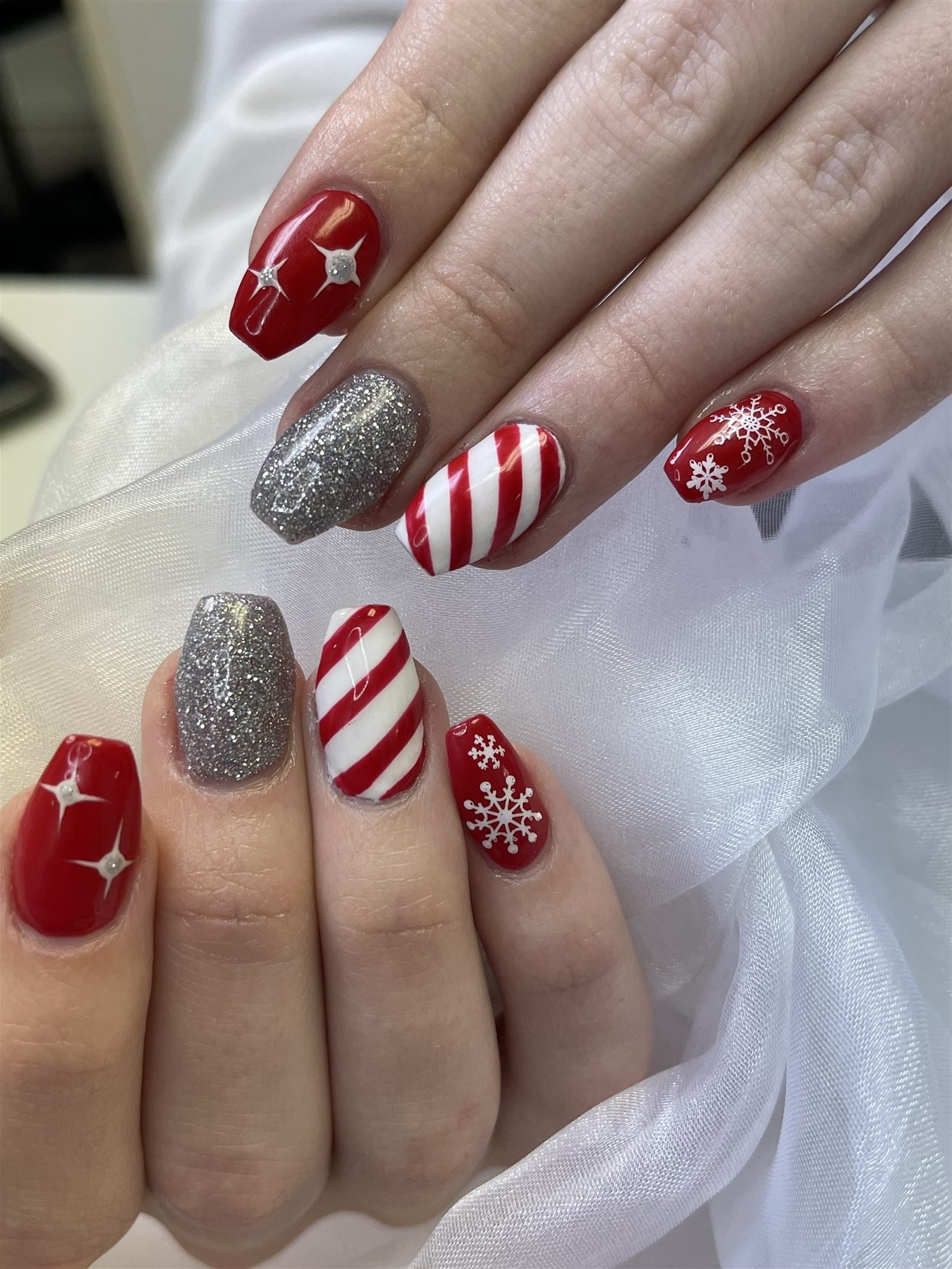 Red white and silver Christmas nails with candy stripes snowflakes and stars