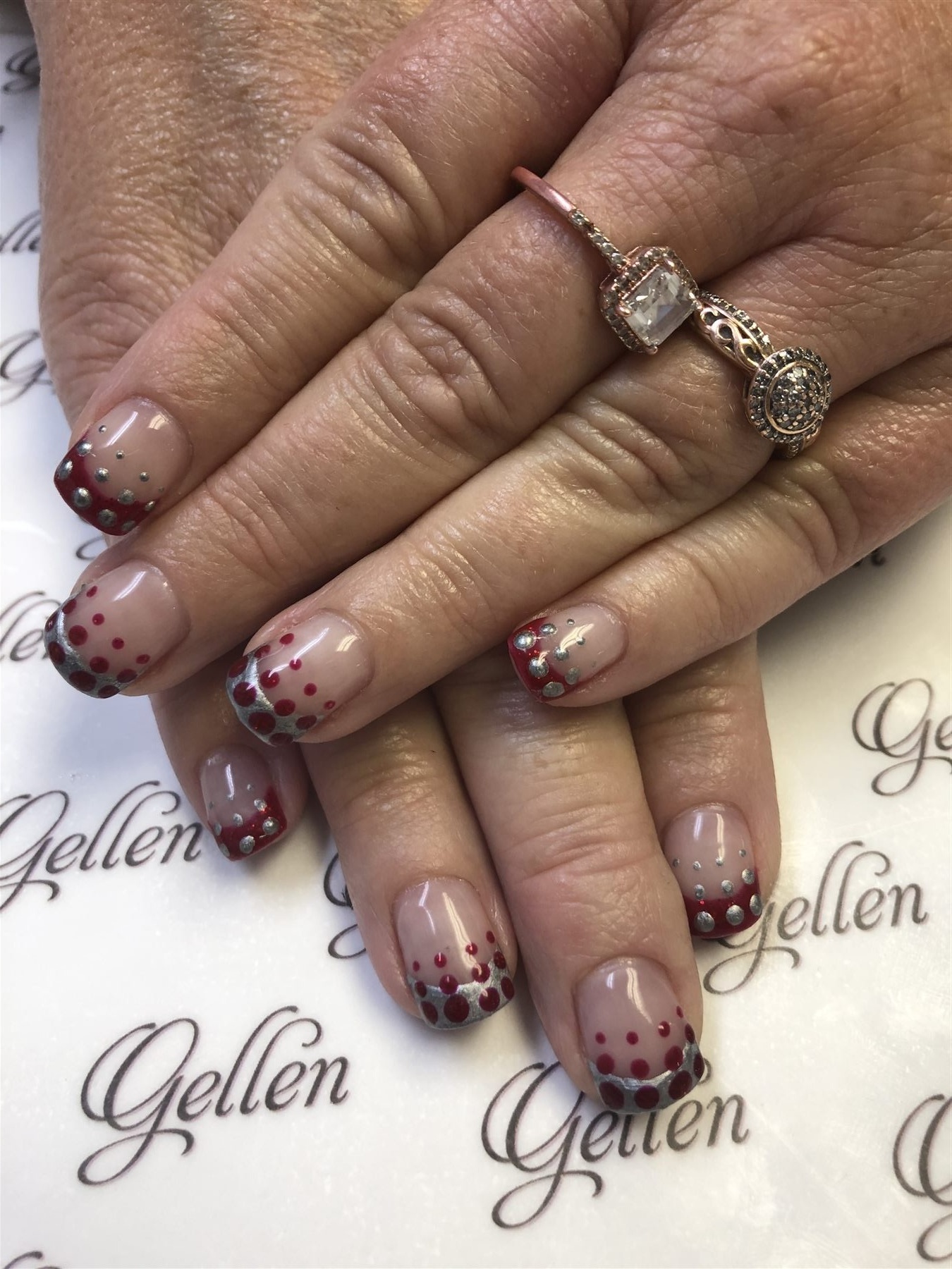 Nude French nails with burgundy and silver bubble accents