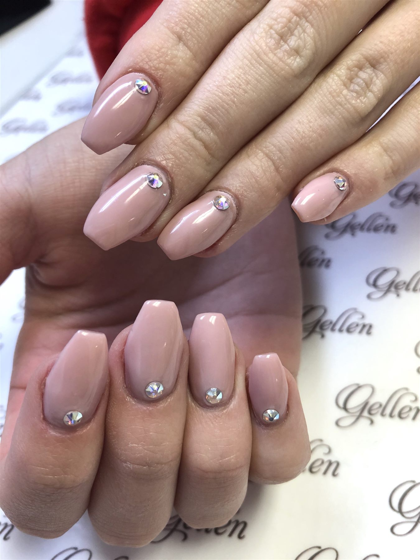 Blush coffin nails with crystal accents at the cuticle