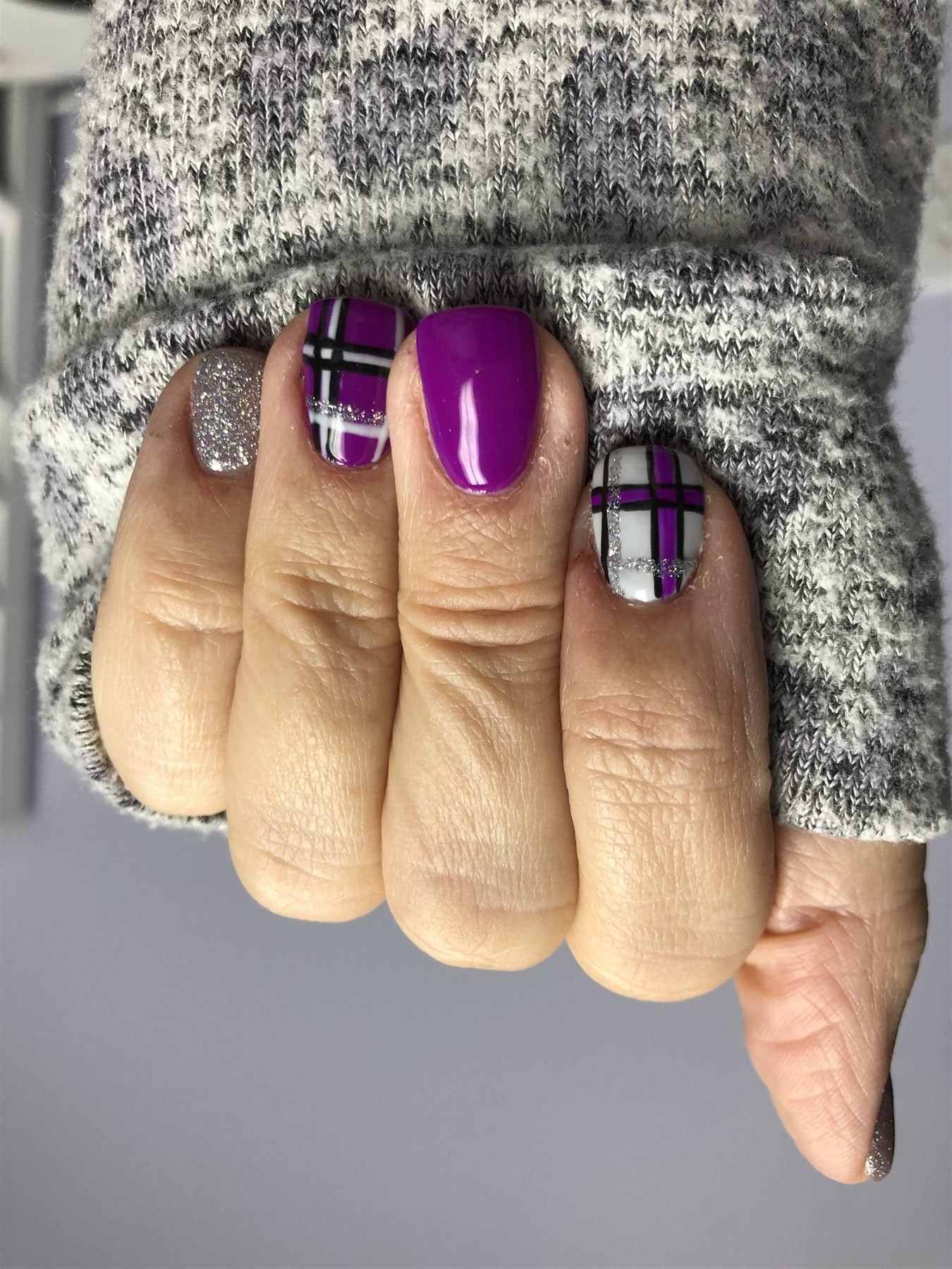 Purple grey white and silver plaid nails styled with knitwear