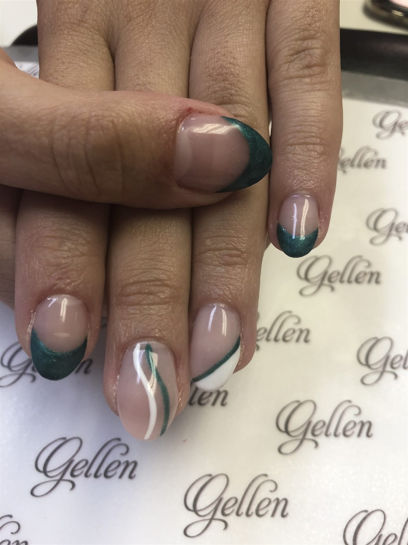 Nude nails with metallic emerald green French accents