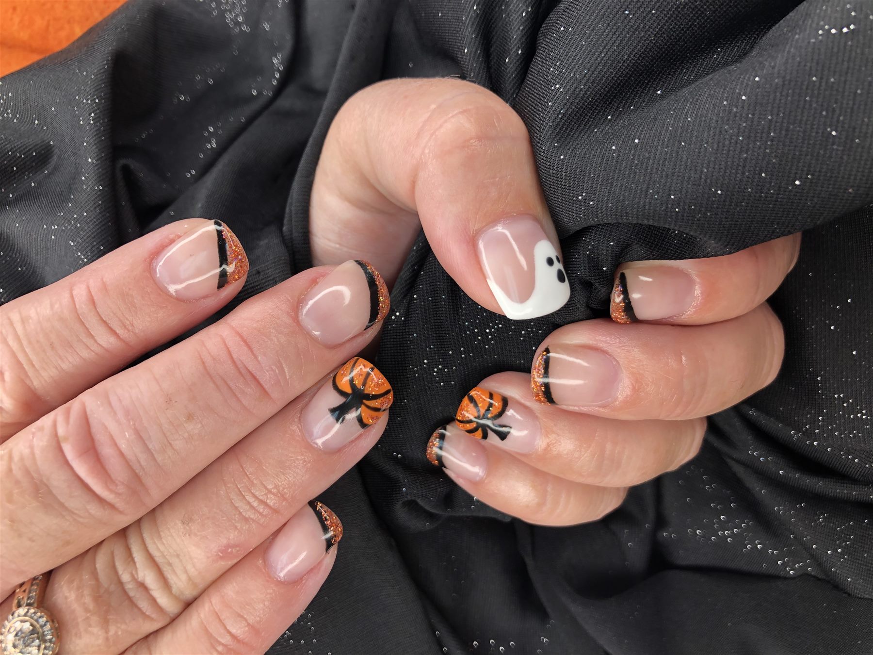 Halloween French nails with orange glitter bows and a white ghost accent