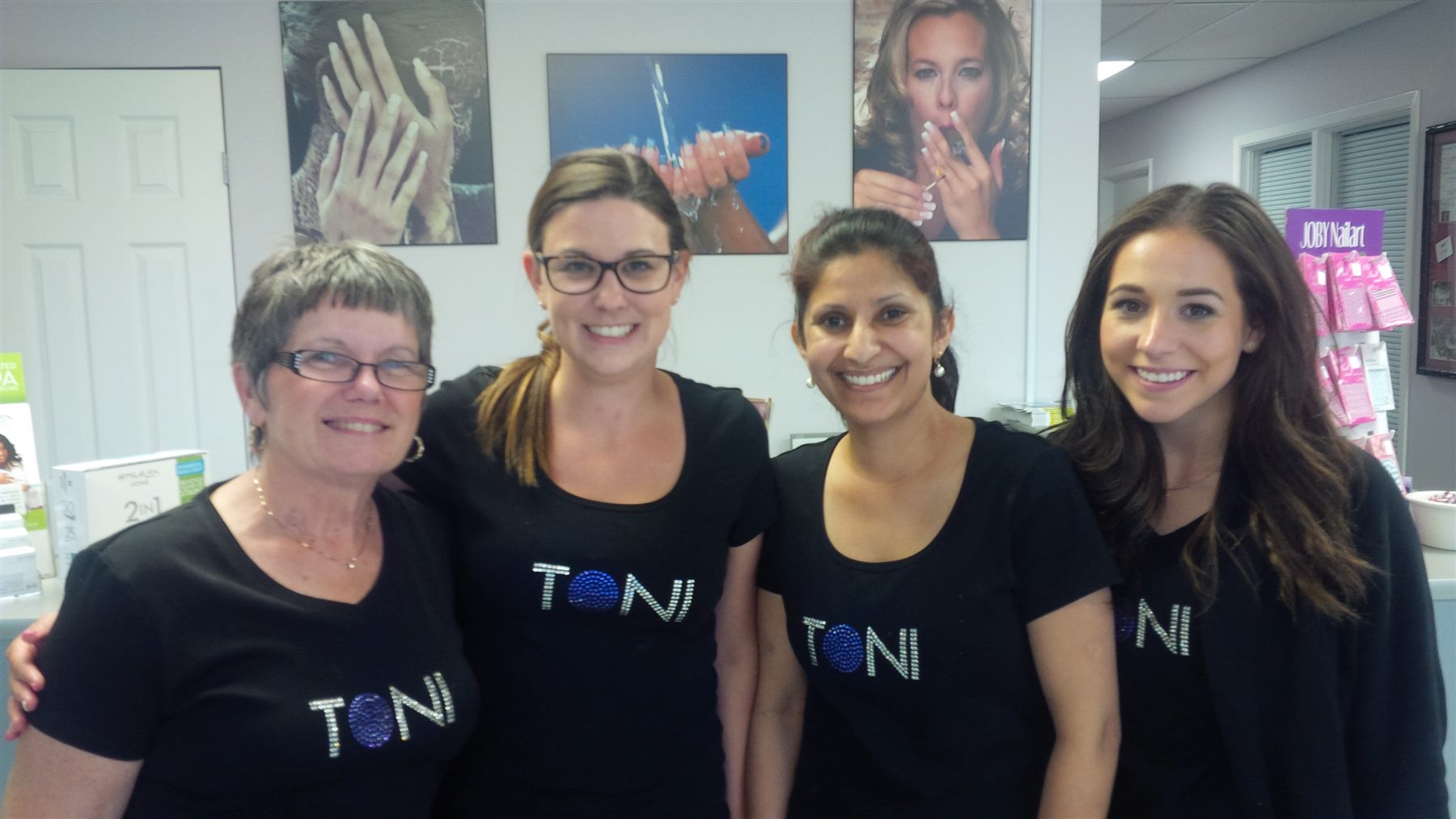 Four TONi nail students wearing matching TONi shirts
